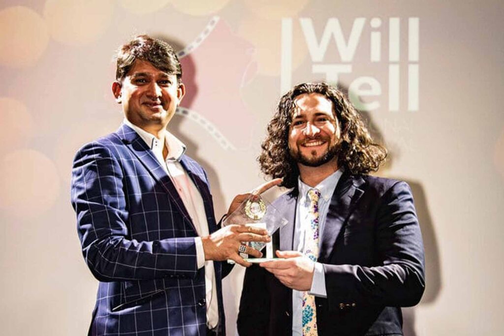 Home 26 A trophy being presented to an I Will Tell International Feature Film Festival Awards winner.