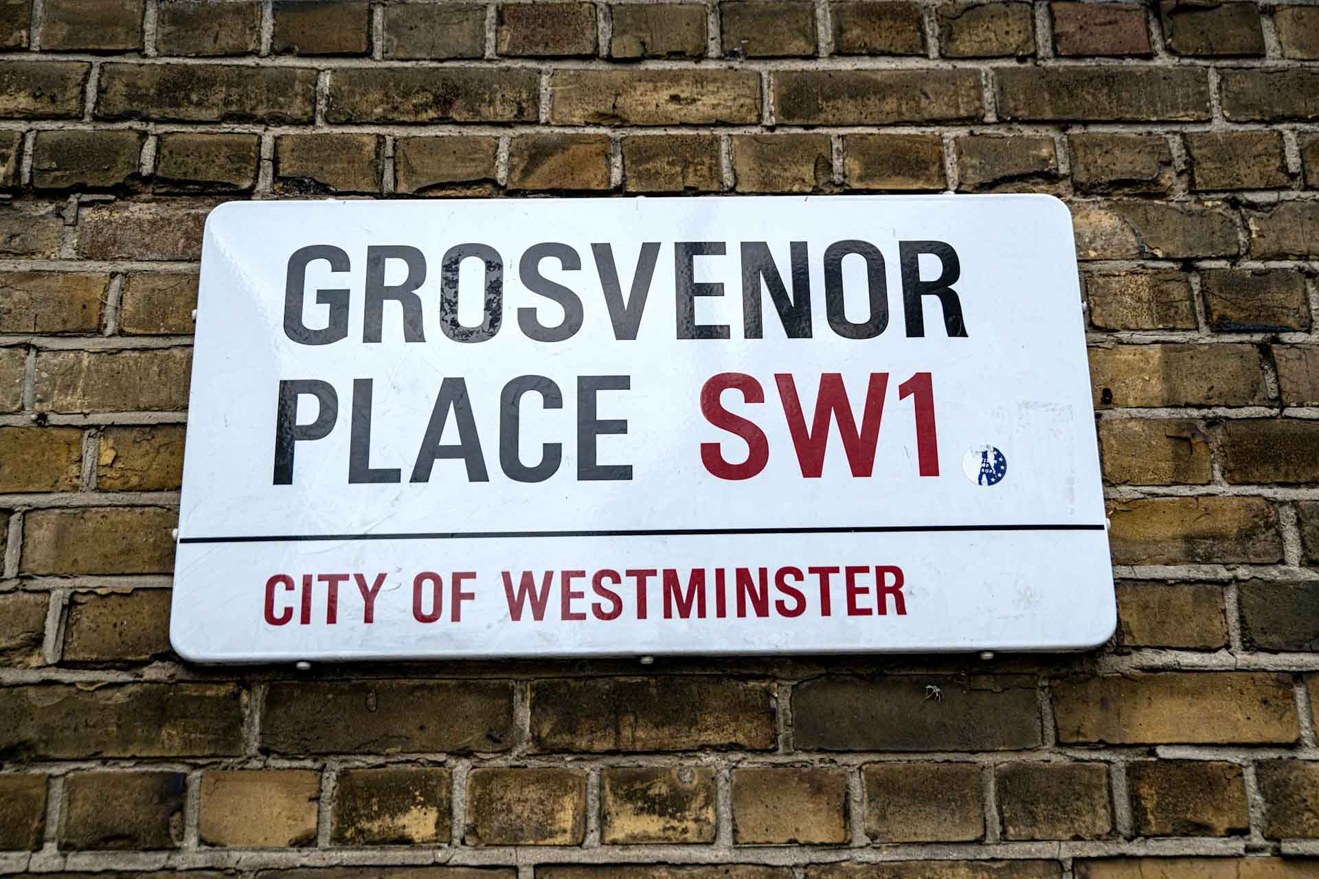 Close up of a London street sign for Grosvenor Place SW1.