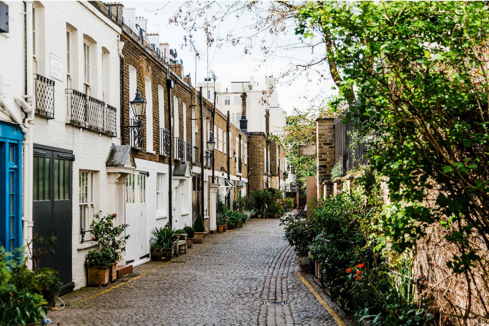 London street scene with mews houses along a cobbled road.